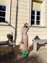 a lady wears a knitted top with a tulle skirt and green boots